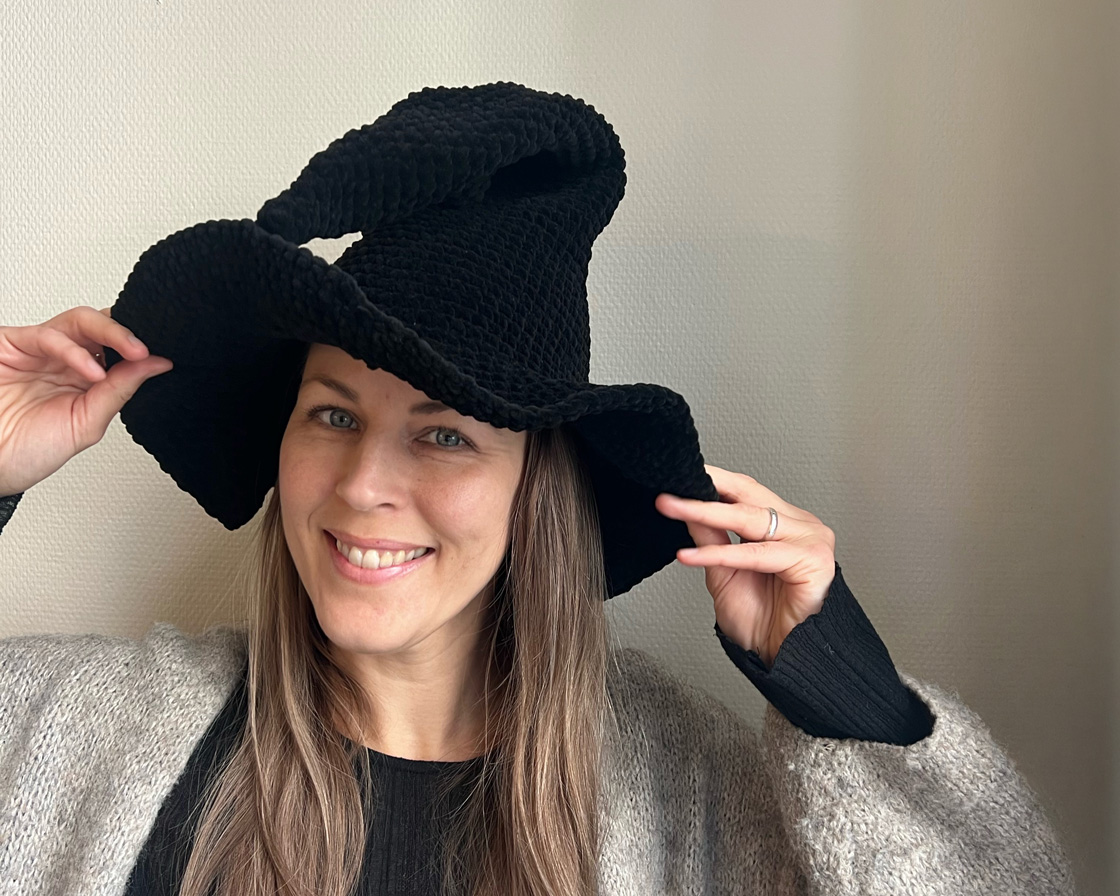 Heklet heksehatt i sort Myboshi Samt chenillegarn med svungen tupp og bølgete brem